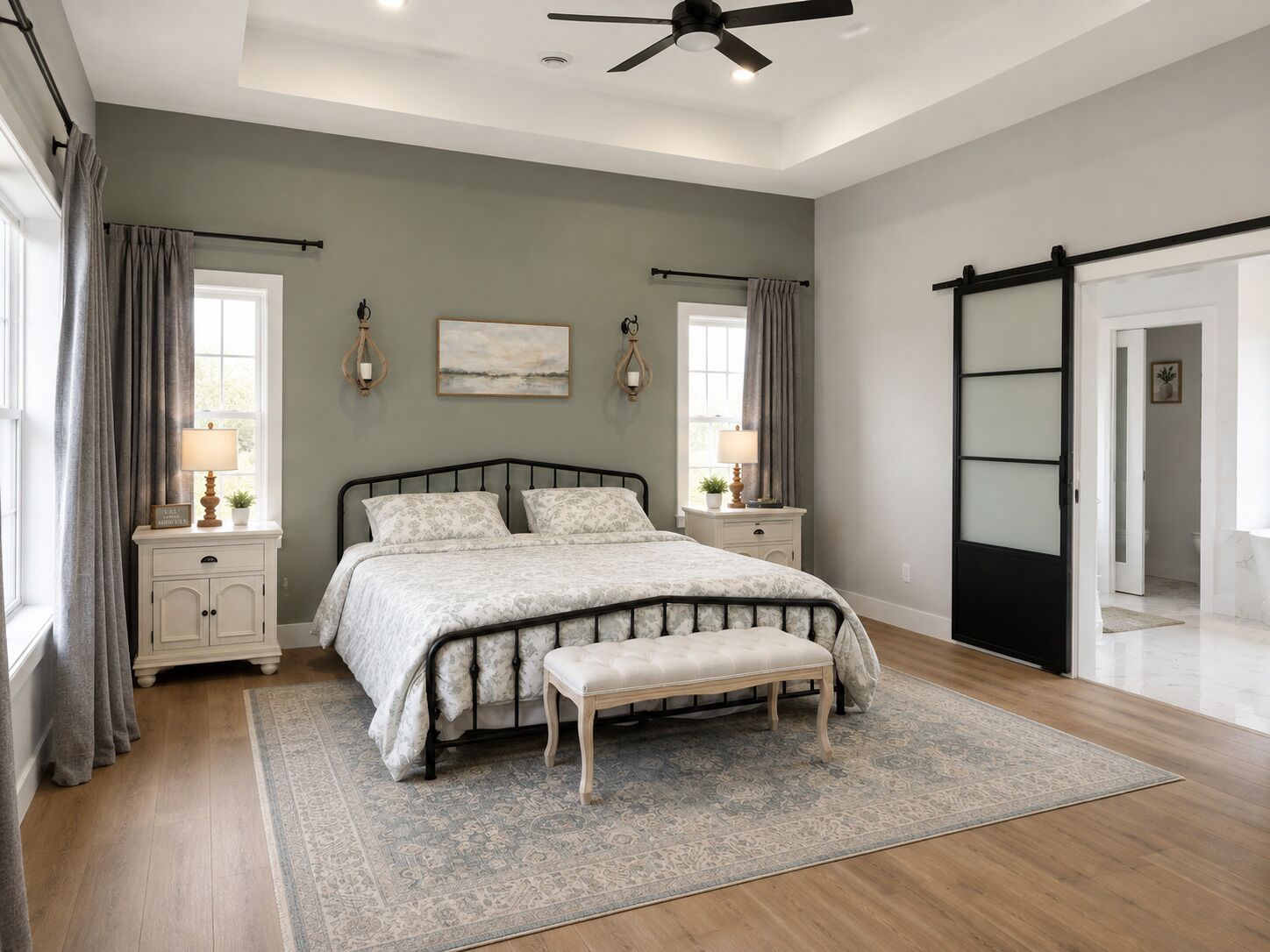 A bedroom with a bed, bedside tables, a bench, a ceiling fan, and a sliding door.