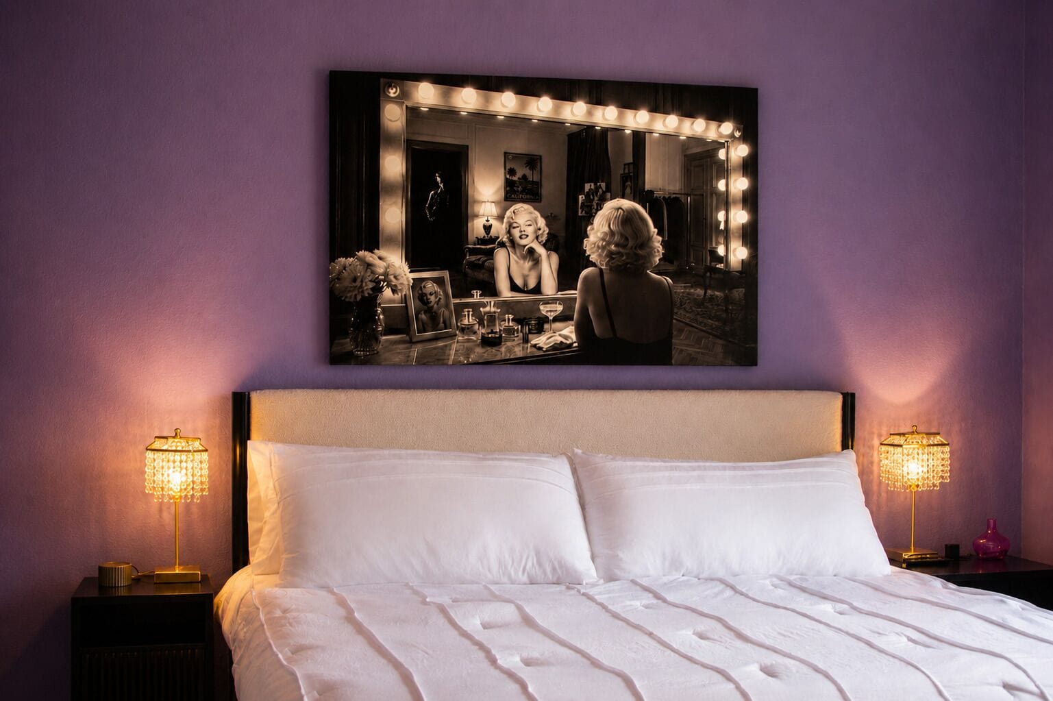 Een slaapkamer met een groot bed, twee bedlampen, een ingelijst kunstwerk boven het bed en een nachtkastje met een lamp.