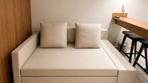 A modern, minimalist room with a sofa, a small table, and a hanging light fixture. - #2 Apartment Vista Playground Beach GAV Resorts (Salinópolis)