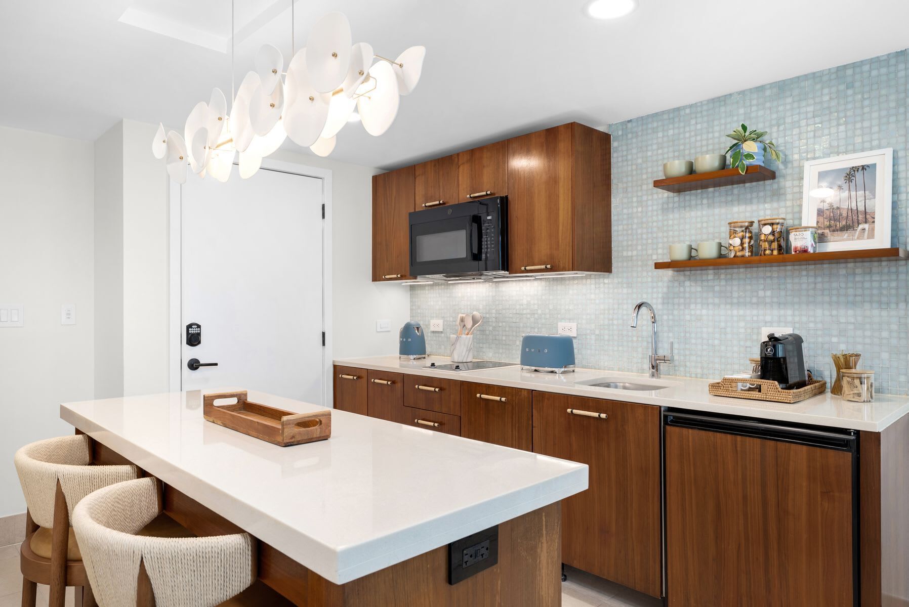 A modern kitchen with wooden cabinets, a white countertop, and a built-in microwave.