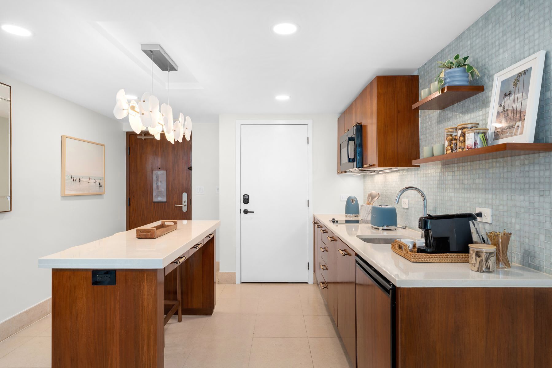Cocina moderna con armarios de madera, encimera blanca y horno empotrado.
