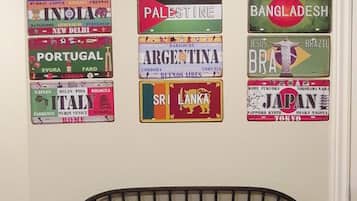 A wall with various country flags and a black metal bench in front.