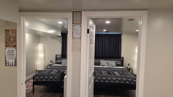 A mirrored room with a bed, a nightstand, and a wall with religious posters.