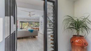 Un interior moderno con una escalera, un sofá y una planta en maceta.