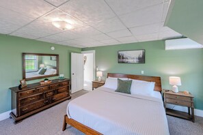 A bedroom with a bed, dresser, nightstands, and a mirror. - Modernized Historic Mountain Getaway (Littleton)