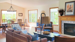 A living room with a sofa, armchairs, a coffee table, a lamp, and a fireplace.