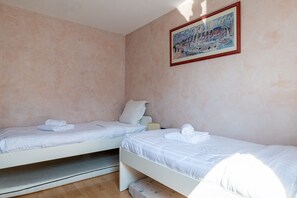 A room with two single beds, each with a pillow and a rolled towel. - **La Casa 67 – 2-Bedroom Apartment in Annecy City Center – Balcony** (Annecy)