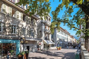 A cobblestone street lined with historic buildings, a shop named 'Le petit Souk,' and a pedestrian walkway. - - (Annecy)