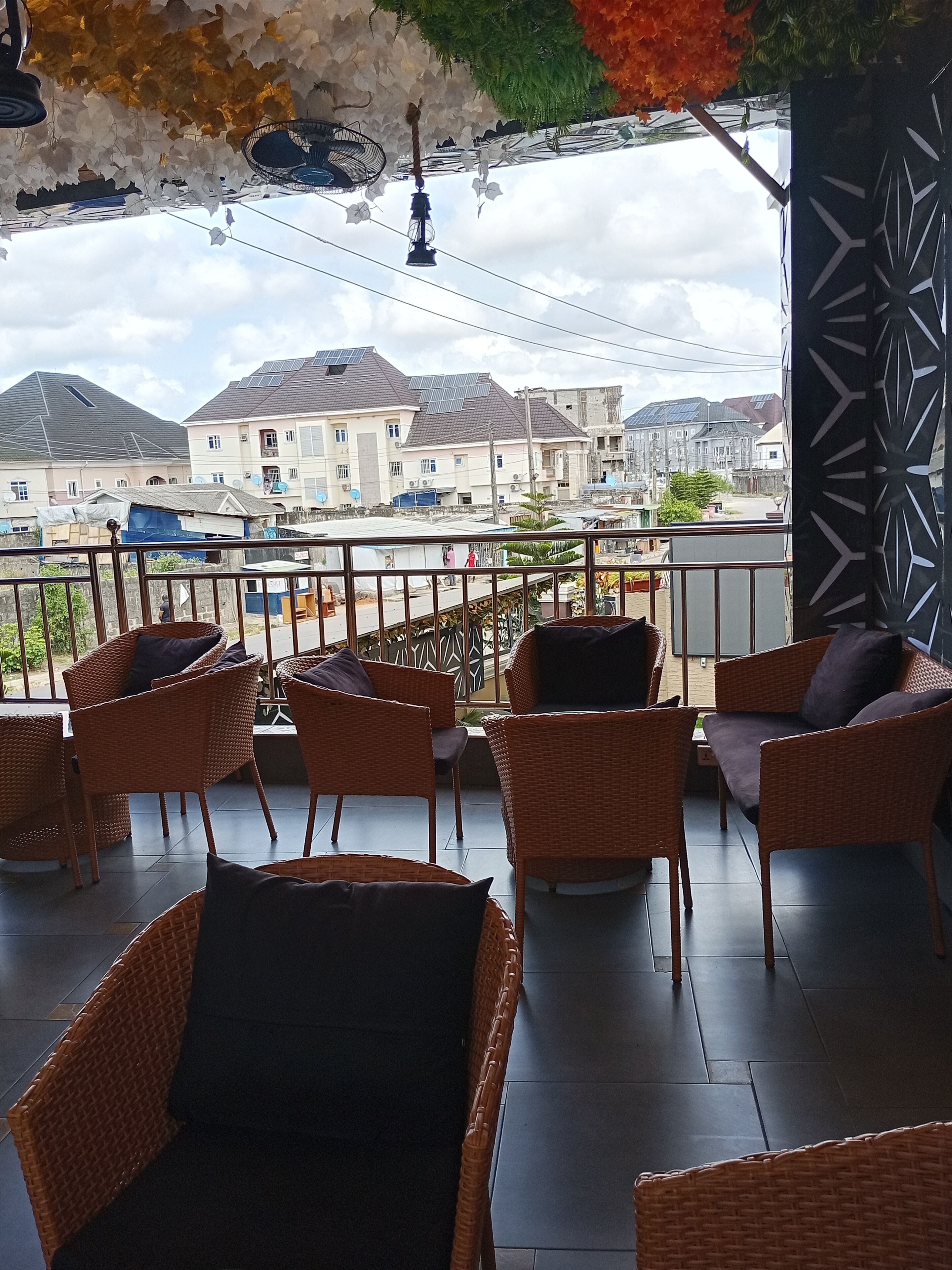 Ein Balkon mit Korbmöbeln und Blick auf Wohnhäuser.