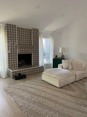 A modern living room with a fireplace, a sofa, a rug, and a lamp. - Lovely modern 3-bedroom house with AC in quiet Houston neighborhood (Houston)