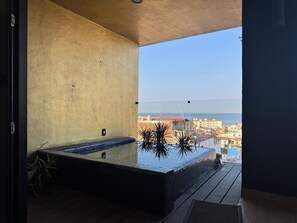 A balcony with a hot tub, a view of the sea, and a cityscape in the background. - Fabulous Penthouse with Ocean and Mountain Views (Puerto Vallarta)