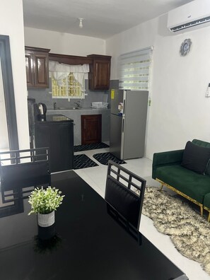 A compact living space with a kitchenette, dining area, and a sofa. - Luxury 1 Bedroom Townhouse Located In Santa Cruz, ST. Elizabeth, Jamaica (Santa Cruz)