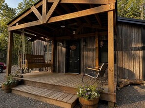 A rustic wooden cabin with a porch, a bench, and a door. -  Ride Trails or go fishing near Clearwater lake. No cleaning fees, pet friendly  (Piedmont)