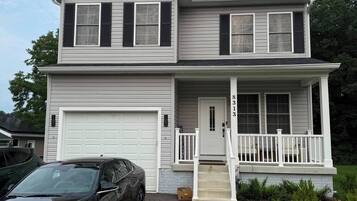 A two-story house with a garage, a front porch, and a driveway.