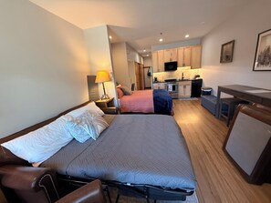 A hotel room with two beds, a desk, a kitchenette, and a bathroom. - The Perfect Ski Escape - Steps to the Gondola (Steamboat Springs)