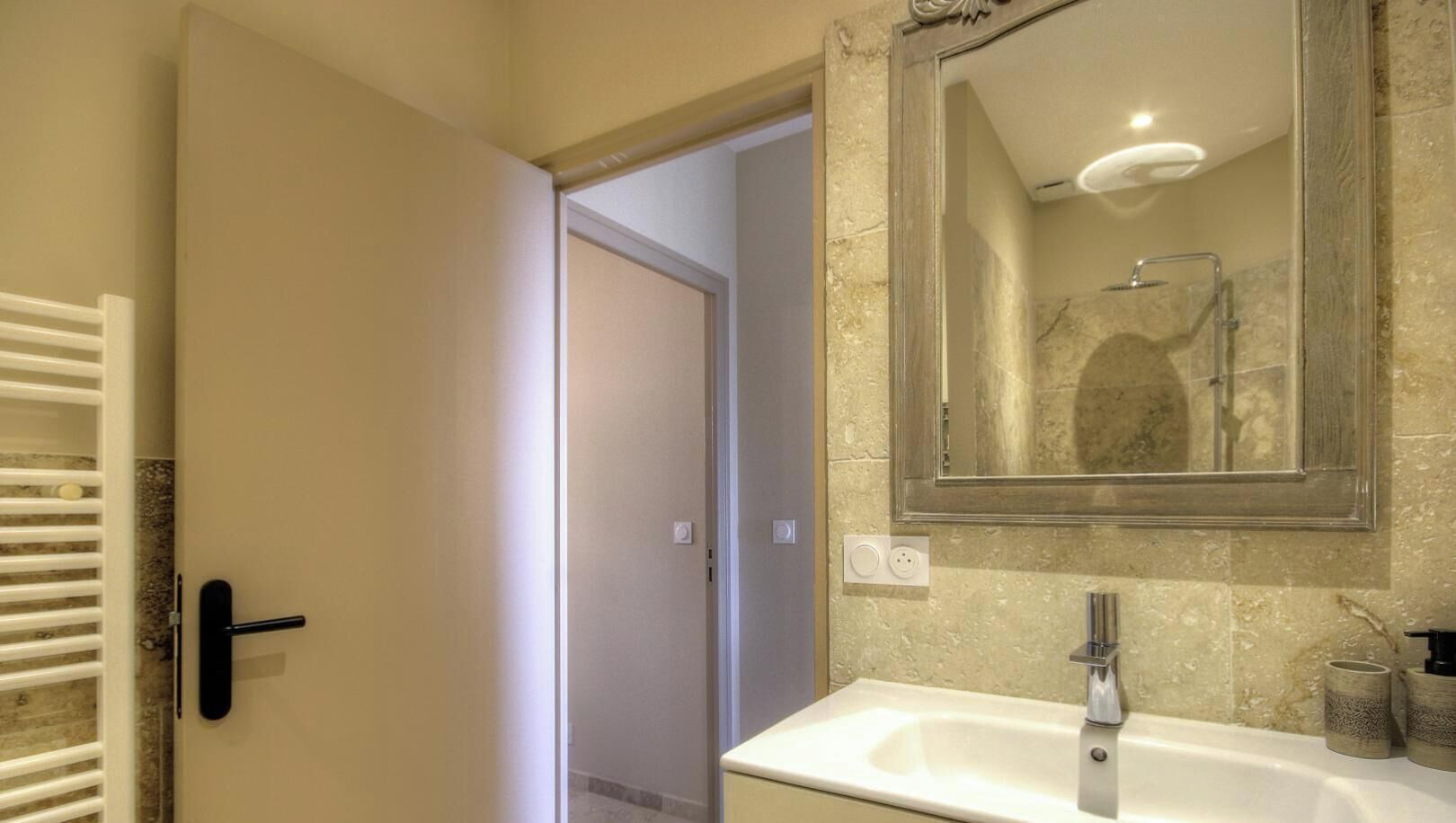 Ein Badezimmer mit Waschbecken, Spiegel und Handtuchhalter.