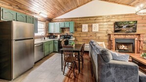 Ein Ferienhaus-Inneres mit Küche, Essbereich und Kamin.