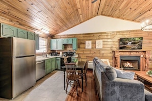 Ein Ferienhaus-Inneres mit Küche, Essbereich und Kamin.