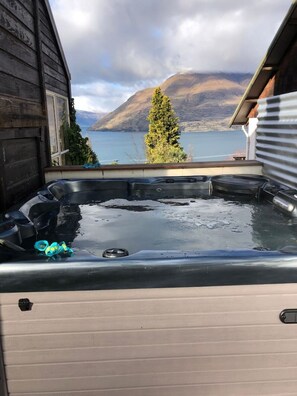 Ein Whirlpool mit Blick auf einen See und Berge.