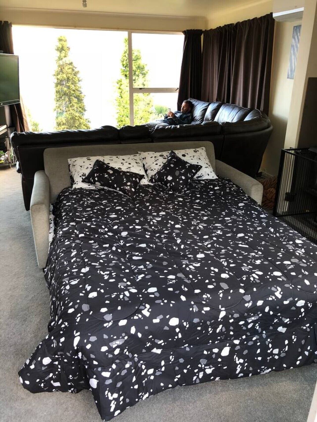 Ein Schlafzimmer mit Bett, Fenster, Sofa und Fernseher.