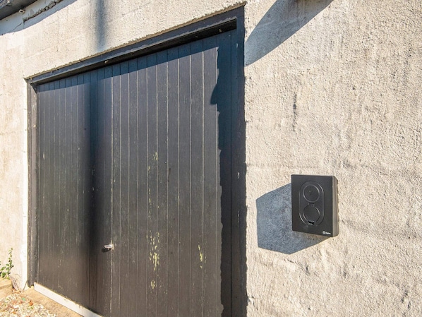 A closed garage door with a security keypad on the wall.