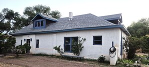 A single-story house with a gabled roof, a chimney, and a small porch. - Casa Tomas - Beautifully restored Adobe from the 1800's.  True NM. (Albuquerque)