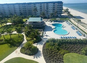 Ein Resort mit großem Pool, Palmen und Blick auf den Strand.