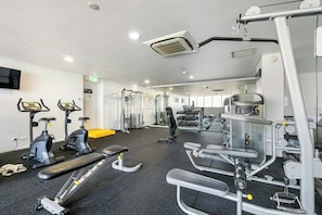 Un gimnasio con equipo de ejercicio, cintas de correr y máquinas de pesas.