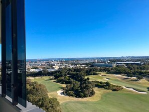 Vista de un campo de golf con un paisaje urbano al fondo.