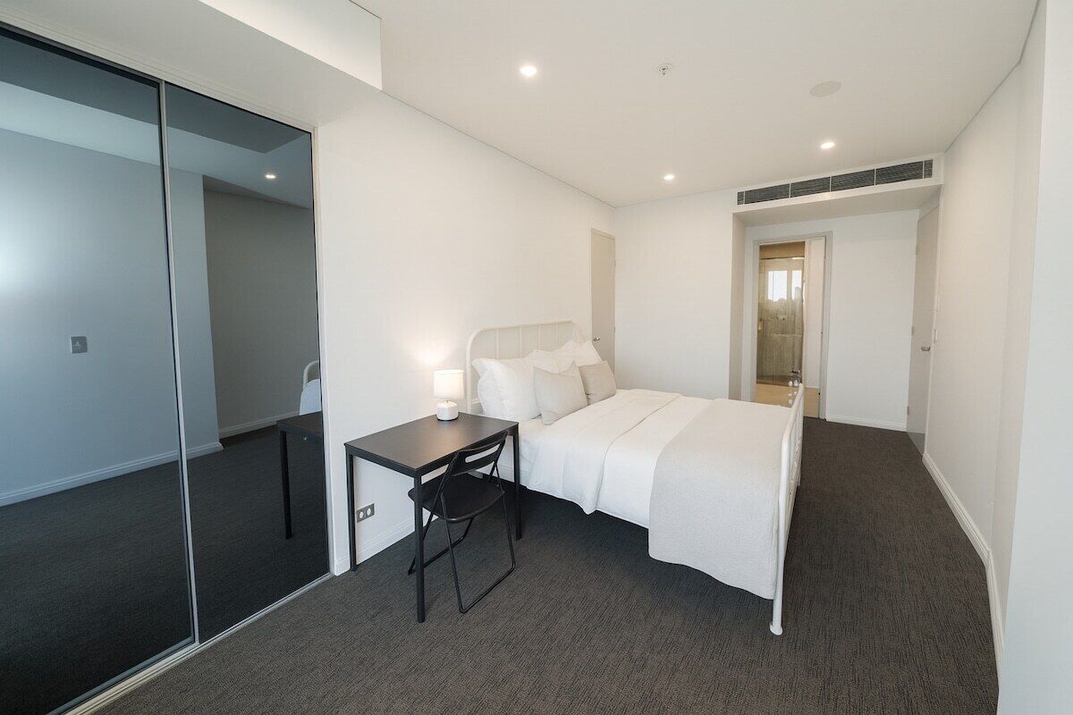 Ein Hotelzimmer mit einem Bett, einem Schreibtisch, einem Stuhl und einem Spiegel.