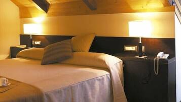 Una habitació d'hotel amb llit, taules de nit, làmpada i telèfon.
