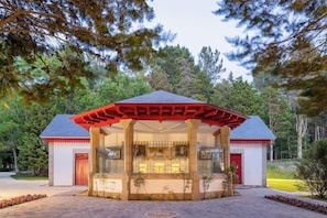 A building with a red roof and a covered entrance area. - Balneario de Guitiriz (Guitiriz)