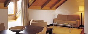 A cozy living room with a sofa, a dining table with chairs, and a coffee table. - Balneario de Guitiriz (Guitiriz)