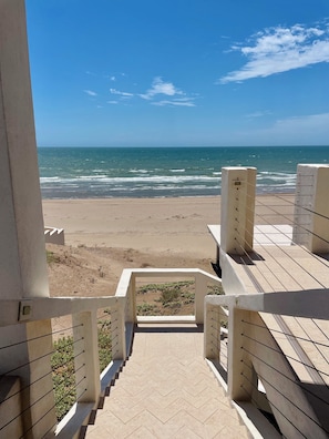 A staircase leading to a beach with a clear view of the ocean.