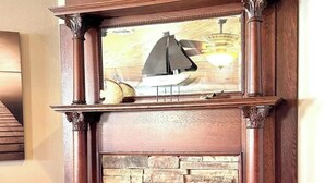 Uma lareira com revestimento de pedra e uma moldura decorativa.