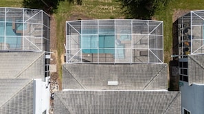 Ein Wohngebäude mit Schwimmbad, überdachter Sitzgelegenheit und einem eingezäunten Spielbereich.