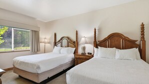 A hotel room with two single beds, a nightstand with a lamp, and a window with curtains. - Midway villa with 1 bedroom, 1 bath, and 2 queen beds at Zermatt Resort. (Midway)