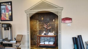 A gym with exercise equipment, a reception area with a fireplace, and a sign indicating steam rooms for women and men. - Midway villa with 1 bedroom, 1 bath, and 2 queen beds at Zermatt Resort. (Midway)