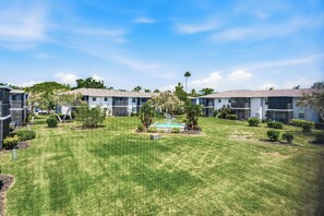 A residential area with multiple two-story buildings, a well-maintained lawn, and a swimming pool. - Fountains of Largo | Perfect Family Vacation Just Minutes from IRB | Communal Pool & Clubhouse (Largo)