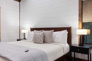 A bedroom with a bed, two bedside tables, and a nightstand. - 5BR Hochatown Cabin: Hot Tub - Game Room - Fits 13 - Min to Lake & Casino (Broken Bow)