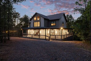 Une maison à deux étages, dotée d’un porche couvert et de fondations en pierre.