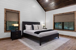 A bedroom with a bed, bedside tables, and a window. - 5BR Hochatown Cabin: Hot Tub - Game Room - Fits 13 - Min to Lake & Casino (Broken Bow)