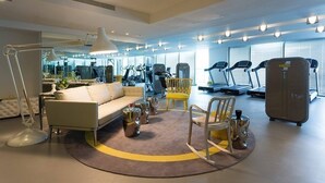 Una palestra moderna con attrezzature per l'esercizio fisico, un divano e un tavolino.