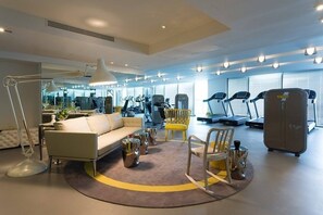 Ein modernes Fitnessstudio mit Trainingsgeräten, einer Couch und einem Couchtisch.