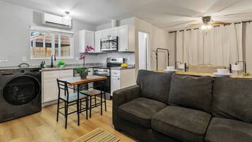 A compact living space with a kitchenette, a dining area, and a seating area with a sofa.