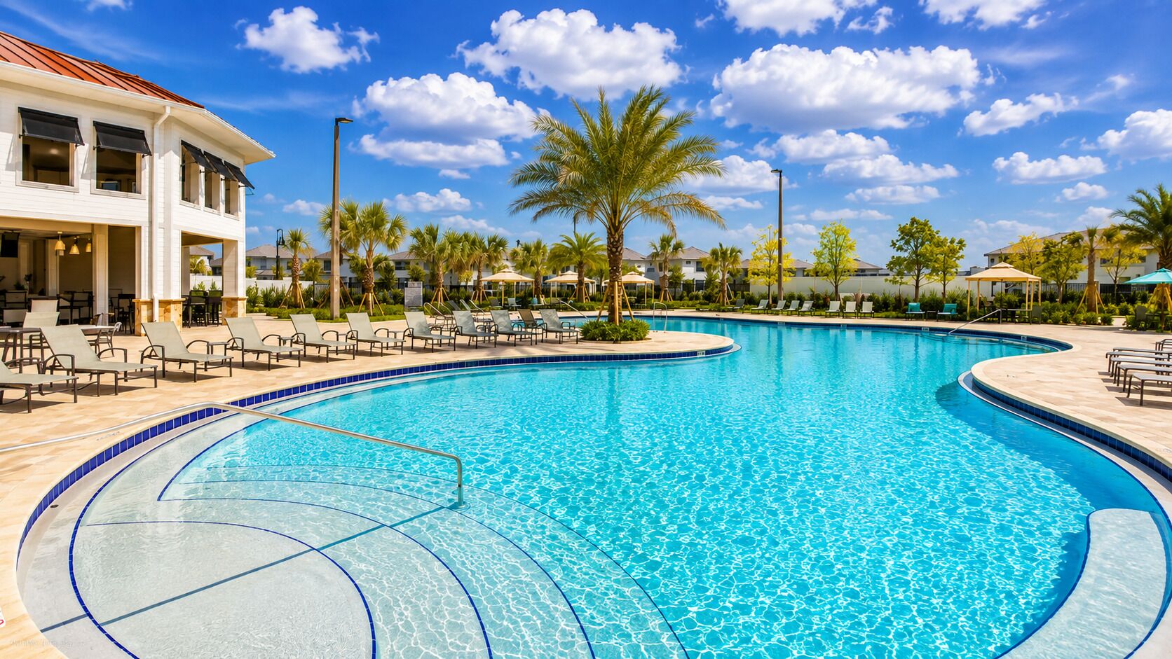 A large outdoor swimming pool with lounge chairs and palm trees.