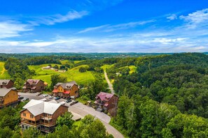 Ein Wohngebiet mit mehreren Häusern, blauem Himmel und einer Straße, die durch eine grüne Landschaft führt.