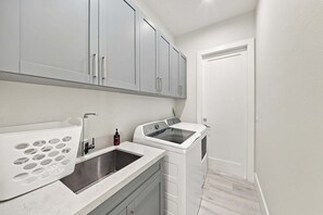 Une petite cuisine équipée d’un évier, d’une cuisinière et d’un placard.