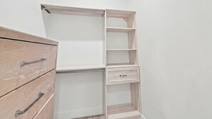 Een hoekkast met open planken en een houten dressoir.
