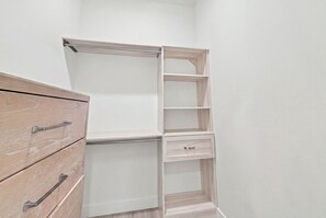 A corner closet with open shelving and a wooden dresser. - New! Coral Tides + Brand 5BR New Luxury Build + Heated Pool + 1 Mile to Vanderbilt Beach! (Naples)